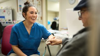 Nurse taking elder man's blood pressure
